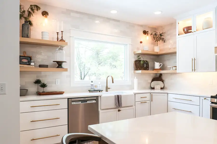 A beautiful sunlit kitchen with white cabinetry and unique décor items.